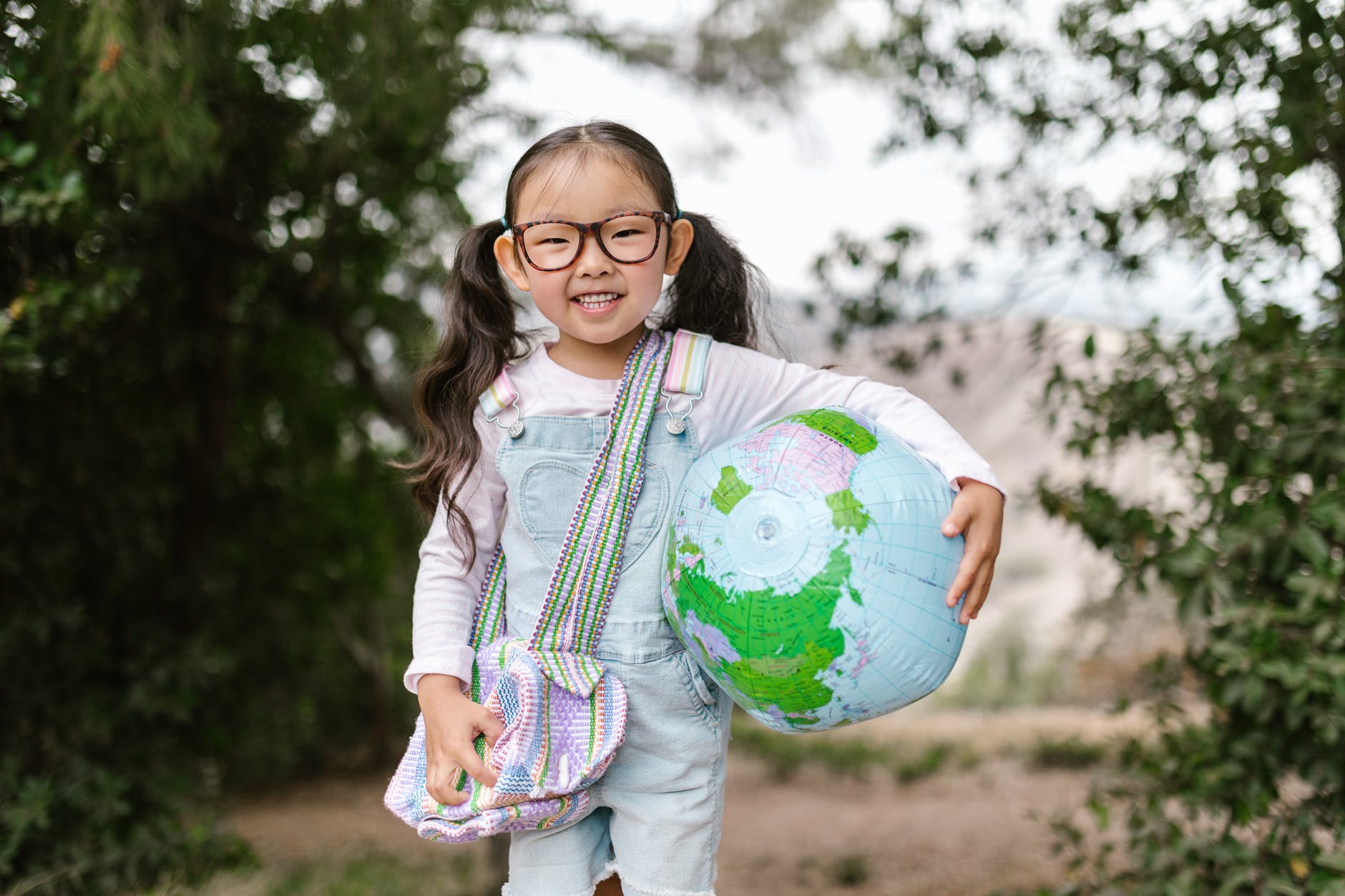 smiling girl holding an inflatable globe
